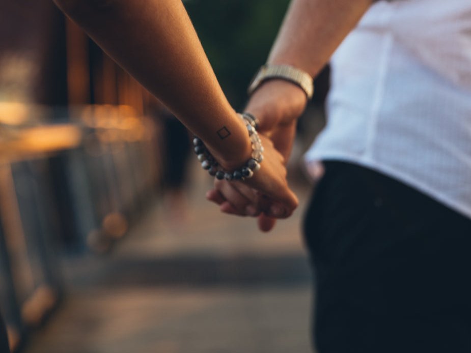 Two people holding hands while walking